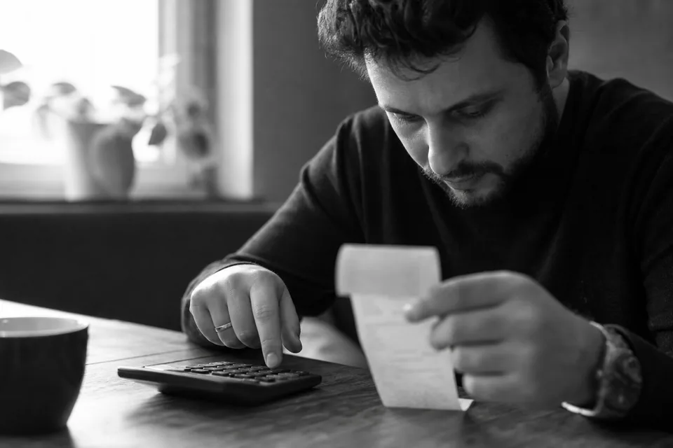 Printed receipt and a calculator on a desk beside a coffee cup