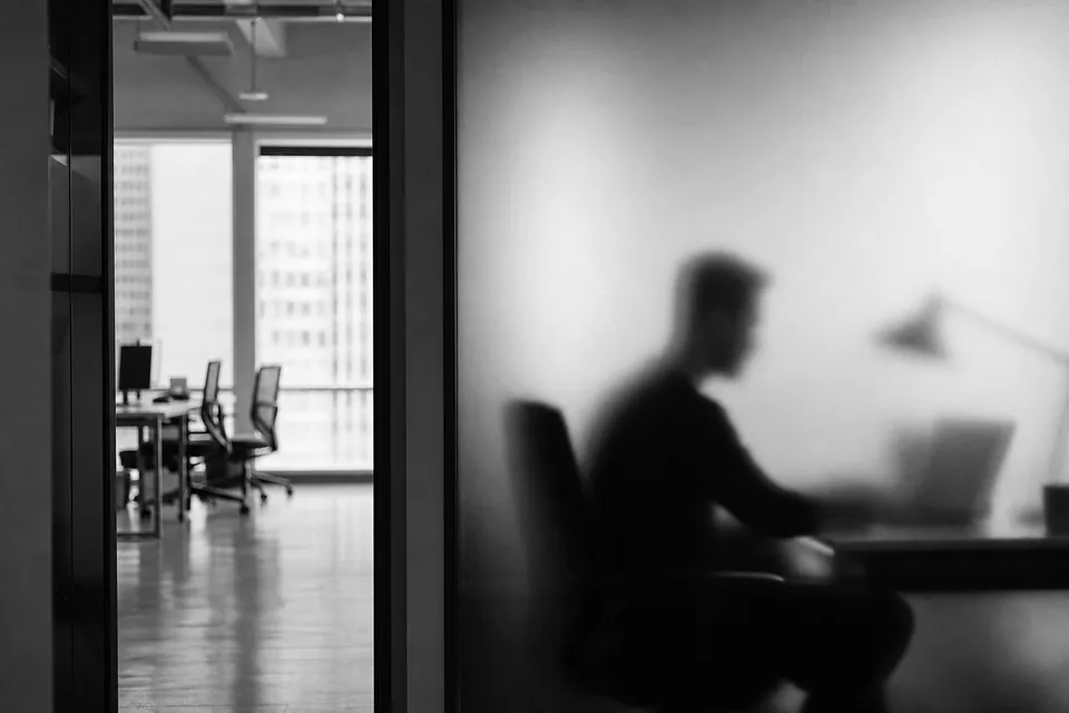 Frosted glass office wall with a blurred person behind it